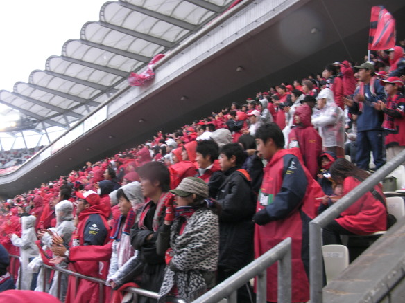 雨降る中応援している鹿島アントラーズサポーターたち カシマサッカースタジアムホーム側ゴール裏